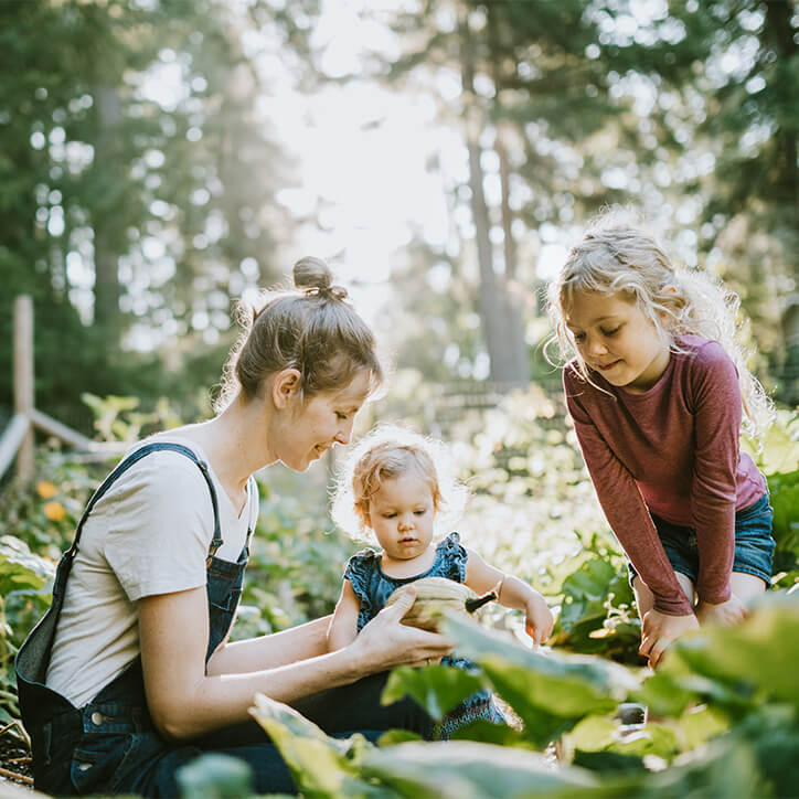 Mutter mit Kindern im Garten